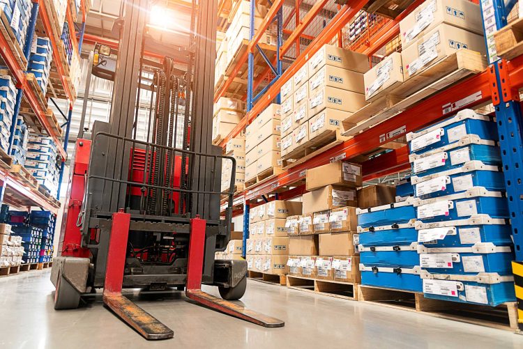 Red forklift rental in a packed warehouse